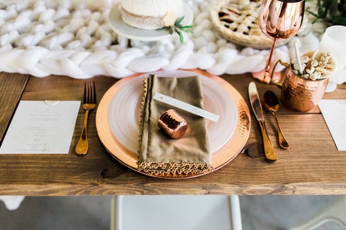 white and copper table setting with menu card for wedding reception